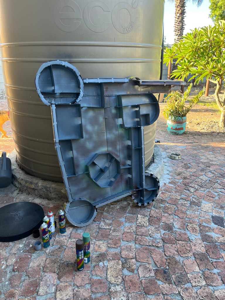 a cardboard floorplan is spray painted in an outdoor paved area